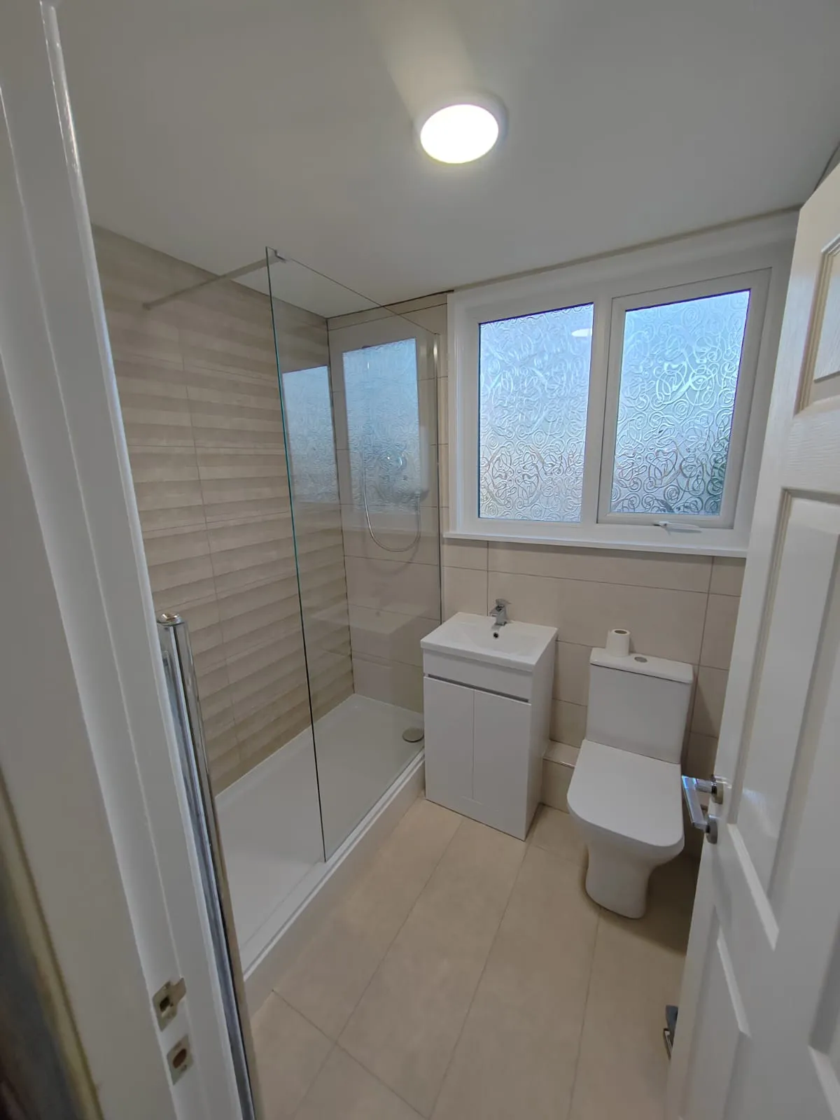 a white toilet sitting next to a walk in shower